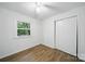 Bright bedroom featuring a ceiling fan, wood floors, a window, and closet at 9818 Starwood Dr, Charlotte, NC 28215