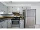 The well lit kitchen features stainless steel oven and refrigerator with ample cabinet storage at 9818 Starwood Dr, Charlotte, NC 28215