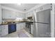 A bright kitchen is finished with stainless steel refrigerator and ample cabinet storage at 9818 Starwood Dr, Charlotte, NC 28215