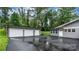 View of home with an asphalt driveway and two-car detached garage with gray siding and white doors at 1035 15Th Nw Ave, Hickory, NC 28601