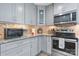 Bright kitchen featuring gray cabinets, granite countertops, stainless steel appliances, and tile backsplash at 1035 15Th Nw Ave, Hickory, NC 28601
