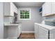 Well-lit laundry room features white cabinetry, granite countertops and a modern washing machine at 1035 15Th Nw Ave, Hickory, NC 28601