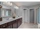 Bathroom featuring double vanity with dark cabinets, tile floors, and framed mirrors and lights at 1035 Ivey Ct, Indian Land, SC 29707