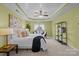 This primary bedroom has a tray ceiling, ceiling fan, and windows that let in a lot of natural light at 1035 Ivey Ct, Indian Land, SC 29707