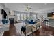 Open-concept living space with fireplace, stylish blue couch, modern seating, adjacent dining area, and bar seating at 1035 Ivey Ct, Indian Land, SC 29707