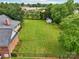 Aerial view of a brick home with a large green backyard, storage shed, and a black chain-link fence at 105 Gold Run Ct, Kings Mountain, NC 28086