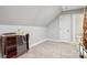 Attic space with neutral carpet, small cabinet, and white door leading to bathroom at 105 Gold Run Ct, Kings Mountain, NC 28086