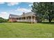 Charming brick home featuring a beautiful backyard with a large, covered porch, mature landscaping, and a lush lawn at 105 Gold Run Ct, Kings Mountain, NC 28086