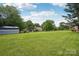 Expansive backyard featuring mature trees, green lawn, and a storage shed, offering ample outdoor space at 105 Gold Run Ct, Kings Mountain, NC 28086