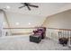 Cozy loft area with plush carpet, arm chair, ceiling fan, and natural light at 105 Gold Run Ct, Kings Mountain, NC 28086