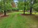 Large and private backyard featuring green grass and mature trees at 105 Prairie Rose Ct, Waxhaw, NC 28173