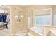 Bathroom showcasing a glass-enclosed shower, soaking tub, and walk-in closet at 105 Prairie Rose Ct, Waxhaw, NC 28173