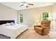 Cozy bedroom featuring carpet, ceiling fan, reading chair, and natural light at 105 Prairie Rose Ct, Waxhaw, NC 28173