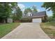 View of the garage with a long driveway and a storage shed in the backyard at 105 Prairie Rose Ct, Waxhaw, NC 28173