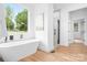 Modern bathroom with a freestanding tub, walk-in shower, and large window at 106 Arbor Dr, Waxhaw, NC 28173