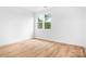 Bright bedroom featuring beautiful hardwood floors and a large window with lush green views at 106 Arbor Dr, Waxhaw, NC 28173