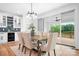 Elegant dining area with modern lighting, a view of the deck and yard, and an open connection to the kitchen at 106 Arbor Dr, Waxhaw, NC 28173