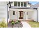 Inviting front entrance with beautiful wood double doors and landscaped garden beds at 106 Arbor Dr, Waxhaw, NC 28173