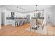 Modern kitchen with white cabinetry, stainless steel appliances, a kitchen island, and an adjacent dining area at 106 Arbor Dr, Waxhaw, NC 28173