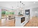 Bright open kitchen featuring an island with seating, modern lighting, and stainless steel appliances at 106 Arbor Dr, Waxhaw, NC 28173