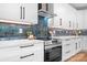 Close-up of a modern kitchen with white cabinets, stainless steel appliances, and a blue tiled backsplash at 106 Arbor Dr, Waxhaw, NC 28173