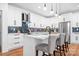Bright kitchen featuring white cabinetry, a central island with seating, modern appliances, and stylish backsplash at 106 Arbor Dr, Waxhaw, NC 28173