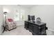 Bright office space includes a large dark wood desk, comfortable chair, and a brightly colored accent chair at 109 Mac Aly, Cramerton, NC 28032