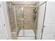 Clean and modern shower featuring glass doors, a built-in bench, a shower caddy, and tan tile surround at 109 Mac Aly, Cramerton, NC 28032