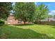 A sprawling lawn and mature trees surround this brick home at 114 Sardis Plantation Dr, Matthews, NC 28105