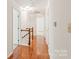Bright hallway featuring hardwood floors, white walls, and classic wood railing staircase at 114 Sardis Plantation Dr, Matthews, NC 28105