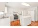 A bright kitchen with stainless steel appliances, a center island, and sleek white cabinetry against hardwood floors at 114 Sardis Plantation Dr, Matthews, NC 28105
