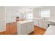 Well-lit kitchen featuring an island, white cabinetry, stainless appliances, and hardwood flooring at 114 Sardis Plantation Dr, Matthews, NC 28105