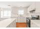 Bright kitchen with white cabinets, stainless steel appliances, and a center island, complemented by gleaming hardwood floors at 114 Sardis Plantation Dr, Matthews, NC 28105