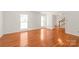 Bright living room with hardwood flooring, neutral paint, and natural light, with entrance to foyer at 114 Sardis Plantation Dr, Matthews, NC 28105
