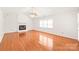 Spacious living room featuring a white brick fireplace, ceiling fan, and ample natural light, all enhanced by hardwood floors at 114 Sardis Plantation Dr, Matthews, NC 28105