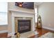 Close-up of a fireplace with a decorative mantel, granite accents, and hardwood floors at 11607 Meetinghouse Dr, Cornelius, NC 28031
