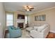 Comfortable living room featuring a fireplace, plush seating, hardwood floors, and large windows at 11607 Meetinghouse Dr, Cornelius, NC 28031