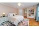A well-lit bedroom featuring a ceiling fan, white trim, and a colorful accent rug on the hardwood floor at 141 Eastover Se Dr, Concord, NC 28025