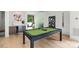 A game room featuring a modern pool table with sleek black legs and access to outdoor deck at 1620 S Tryon St, Charlotte, NC 28203