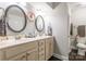 Bathroom featuring double sinks with oval mirrors, a white vanity, and dark wood floors at 1804 Fairlawn Ct, Rock Hill, SC 29732