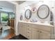Bright bathroom with double sinks, stylish vanity, and dark wood floors, with a glimpse into the bedroom at 1804 Fairlawn Ct, Rock Hill, SC 29732