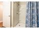 Clean shower featuring white tiled walls, a shower head, and a blue floral shower curtain at 1804 Fairlawn Ct, Rock Hill, SC 29732