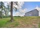 Spacious backyard featuring a lush lawn, mature trees, and a charming two-story gray home at 2000 Plainfield Dr, Bessemer City, NC 28016