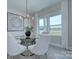 Dining room with glass table, modern light fixture, neutral paint and lots of light at 2000 Plainfield Dr, Bessemer City, NC 28016