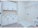 Well-organized laundry room with overhead cabinets, folding counter, and integrated utility sink at 2000 Plainfield Dr, Bessemer City, NC 28016