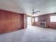 Spacious living room with wood-paneled walls, carpeted floors, and cozy fireplace at 201 Robinson Rd, Gastonia, NC 28056