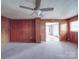 Expansive living area with wood-paneled walls and carpet offers versatile potential at 201 Robinson Rd, Gastonia, NC 28056
