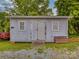 View of a wooden shed with double doors and two windows in the backyard at 201 Robinson Rd, Gastonia, NC 28056