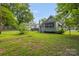 Backyard shows the house with a fenced yard and green trees at 222 W Mccubbins St, Salisbury, NC 28144