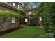 Expansive backyard with lush green grass, mature trees, and a charming covered back porch at 2221 Kenmore Ave, Charlotte, NC 28204